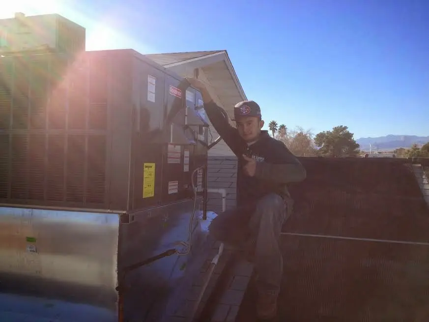 HVAC technician performing AC Tune-Up on a rooftop unit in Fargo